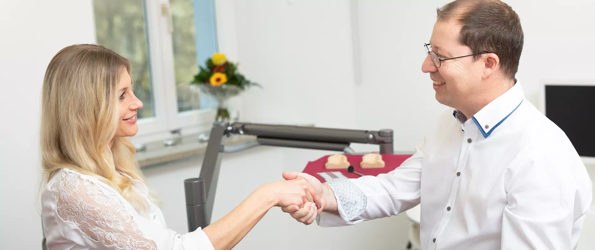 Eingang zur Praxis mit einem zufriedenen Patienten, der die Praxis verlässt